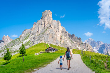 Fototapeta premium Tourists walking along path near giau pass in dolomites, italy