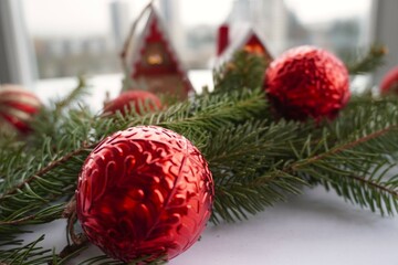 Two red Christmas decoration and a fir branch for Christmas atmosphere