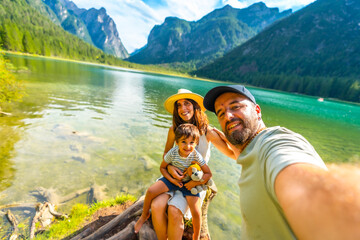 Family taking selfie at lake dobbiaco in the dolomites, italy