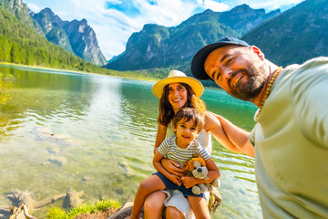 Family taking selfie at lake dobbiaco in the dolomites