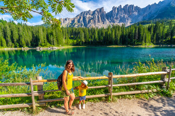 Tourists admiring breathtaking lake carezza and latemar in dolomites, italy