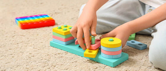 Little girl playing with building blocks at home, closeup. Autistic disorder concept