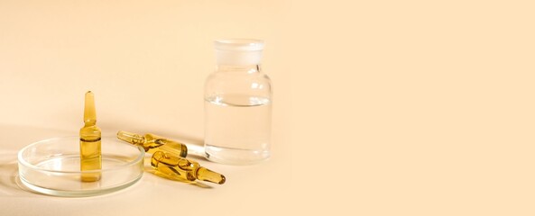 Medical ampules and petri dish and bottle on beige background with space for text