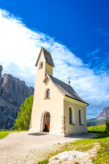 Small church overlooking the dolomites in summer, italy