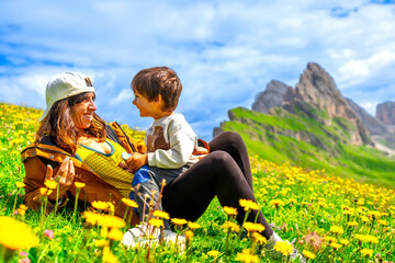 Mother and son enjoying the view of seceda mountains in the dolomites