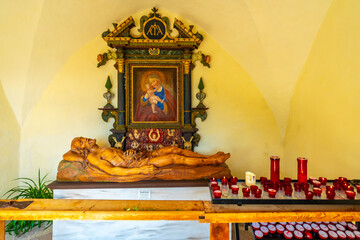 Wooden statue of jesus christ and painting of madonna and child in santa maddalena church