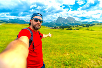 Naklejka premium Tourist showing alpe di siusi meadow and sassolungo in dolomites, italy