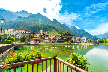 Fototapeta premium Alleghe reflecting on the lake in the dolomites, italy, during a summer day