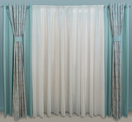 Straight, combined, turquoise curtains and translucent tulle without a pattern on a cornice with eyelets.