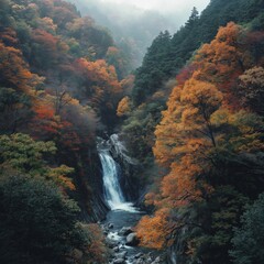 Majestic waterfall amidst vibrant autumn foliage in serene mountain landscape
