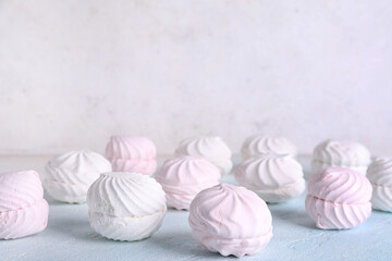 Lots of tasty marshmallows on table against white background