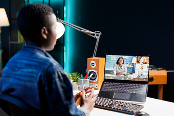 African american female student engaged in an online discussion with her colleagues on digital...