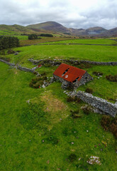 Aerial view of derelict farm building in mountainous terrain
