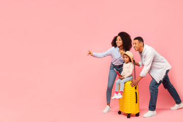 Trip and vacation offer. Black family showing free space for advertisement on pink studio...