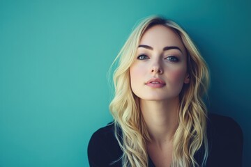 Fototapeta premium Portrait of a Young Woman with Long Blonde Hair Against a Turquoise Background