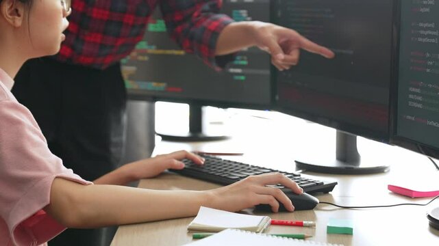 Slow motion back end or software developer manager supervising his team on new application program development on debugging and solving complex code algorithms on monitor. Burgeoning