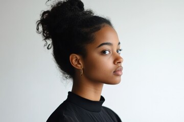 Elegant Profile Portrait of a Young Woman with Natural Hair Against a Minimalist Background