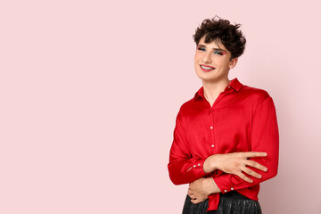 Young transgender woman on pink background