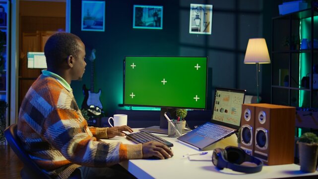 African american advisor reviewing legal balance at his desk next to green screen, examining capital funds statistics for accounting analysis. Banking expert evaluating company budget. Camera B.