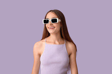 Young woman in sunglasses with diastema on lilac background