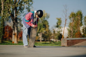 Skateboarder wearing helmet preparing skateboard in skatepark