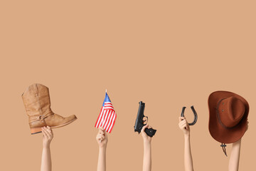 Female hands with cowboy accessories, gun and flag of USA on color background