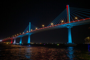 Fototapeta premium Illuminated Bridge and Boats at Night