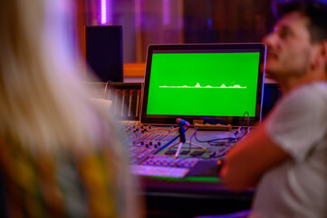 Selective focus on equalizer on computer monitor at music studio.