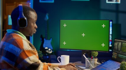 Video maker editing montage clips on coloring software next to mockup, working on color correction...