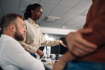 Project manager leading a team meeting, explaining strategy on computer screen