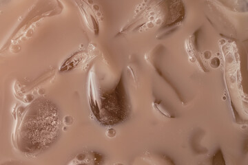 Creamy iced beverage or coffee with droplets and ice cubes in mocha mousse color 2025