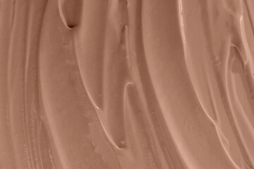 Creamy chocolate mixture swirled smoothly on a surface close-up, mocha mousse color 2025
