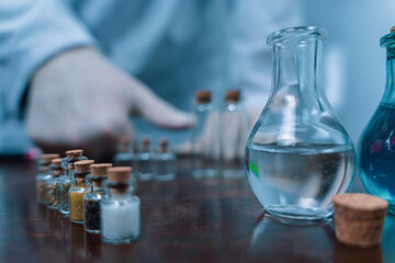 Scientist arranging vials with clear and blue liquids