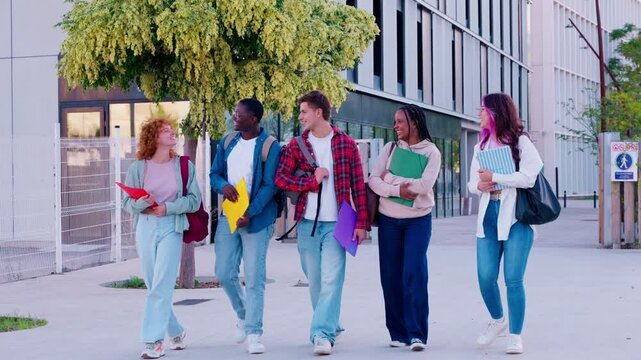 Group of diverse students walking on campus, holding books and folders, smiling and talking. Ideal for themes like education, teamwork, youth, diversity, and college life.