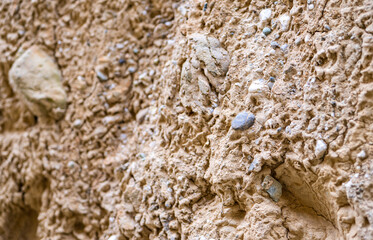 Stones in sand clay geological formations close up macro yellow sandy colour