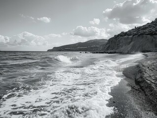 Rocky shoreline with crashing ocean waves. A serene coastal landscape with overcast skies.