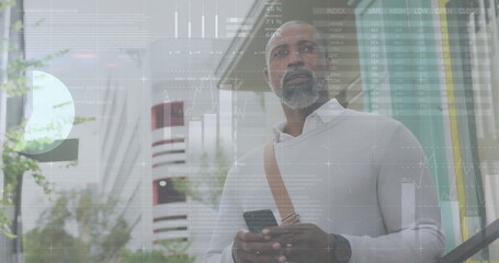 Image of diagrams and data processing over african american man using smartphone in city