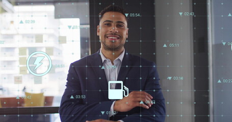 Image of ecology icons and data processing over biracial casual businessman smiling in office