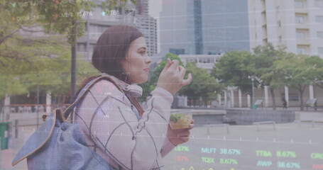 Image of diagrams and data processing over caucasian woman walking and eating in city