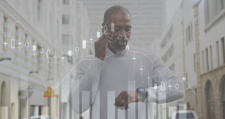 Image of diagrams and data processing over african american man talking on smartphone in city