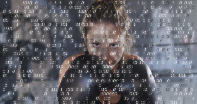 Image of binary coding over caucasian woman wearing boxing gloves at gym - Powered by Adobe