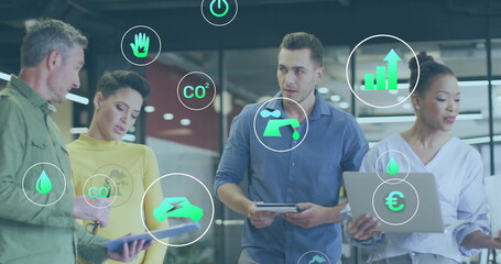 Image of ecology icons over diverse colleagues discussing work in office