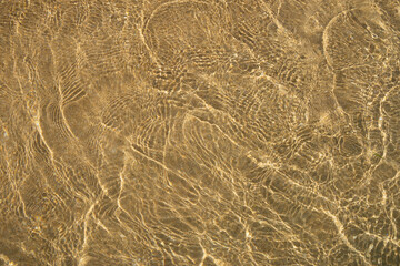 Abstract of waves lapping over golden sand