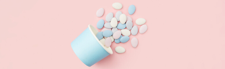 Traditional Easter Portuguese candies. Colorful Sweets in a blue paper cup on pink background © Darya Lavinskaya
