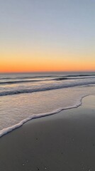 Serene beach at sunset with gentle waves and soft colors.