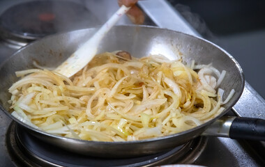 Pans with chicken meat and pomegranate stand on the stove, frying chicken, cooking, real picture in the kitchen