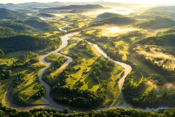 Aerial view of a winding river through lush green hills at sunrise.
