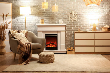 Interior of stylish cozy living room with fireplace, armchair and glowing lamps in evening