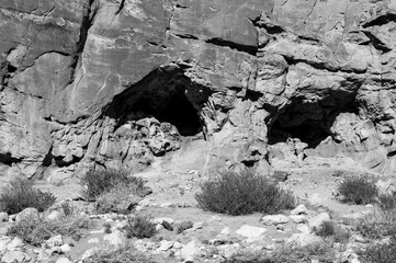 A rocky cliff with a cave in the middle