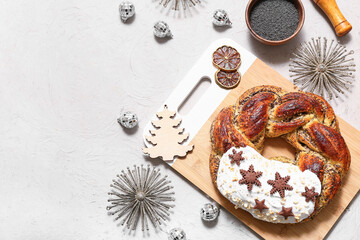 Wooden board with tasty Christmas pastry wreath, decor, mortar and cookies on white background
